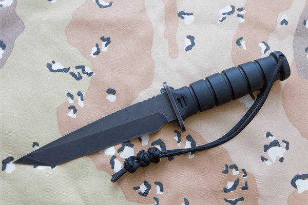 black tactical knife on a camouflage background