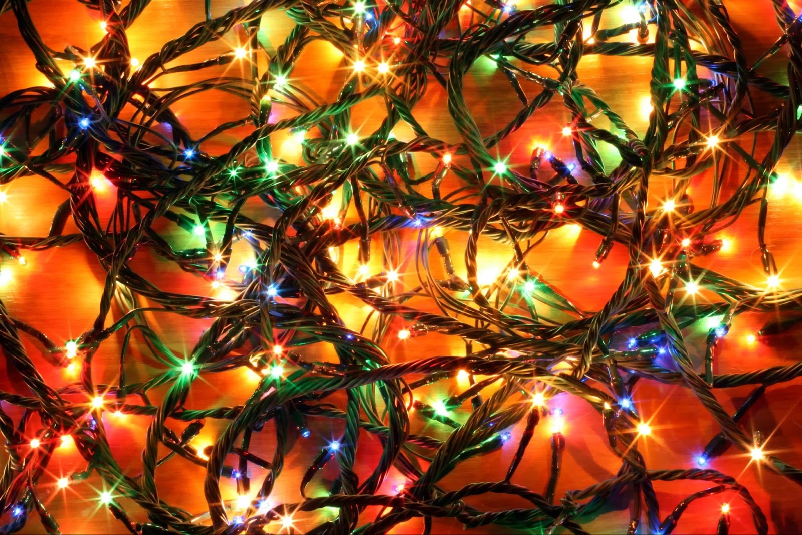 Tangled bunch of multicoloured Christmas lights, glowing green, red, blue and gold