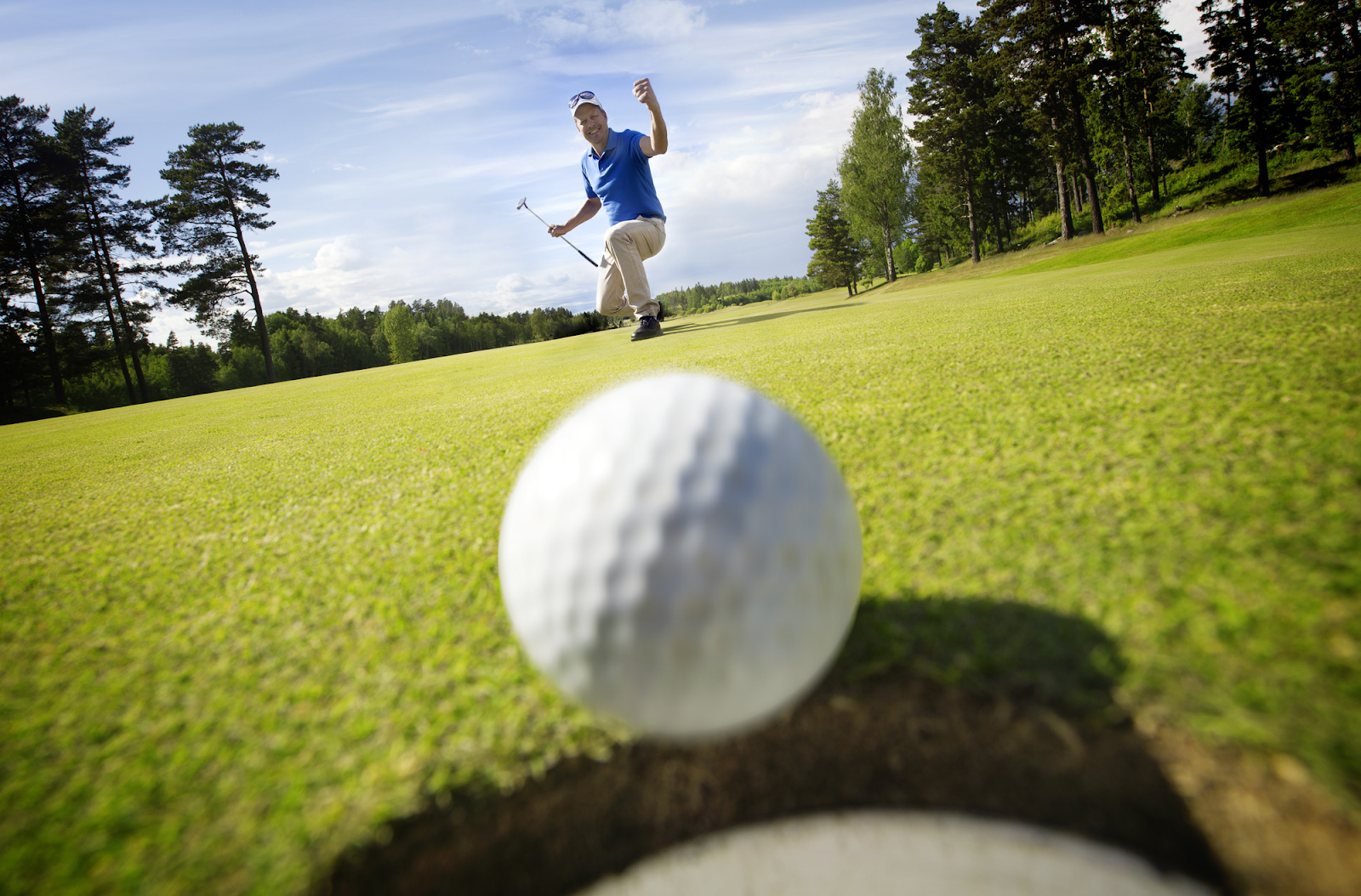 Golfer cheering as ball goes in hole