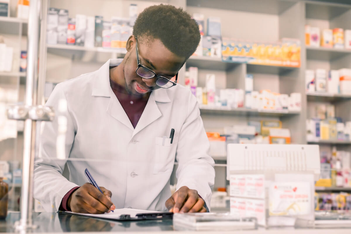 E prescribing software: pharmacist writing on a piece of paper