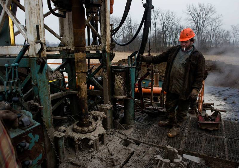 A rig hand works the controls while changing out a drill pipe at a Knox Energy Inc. oil drilling site in Knox County, Ohio, U.S., on Dec. 8, 2014.