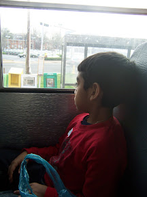 Child looking out a school bus window at the landscape.