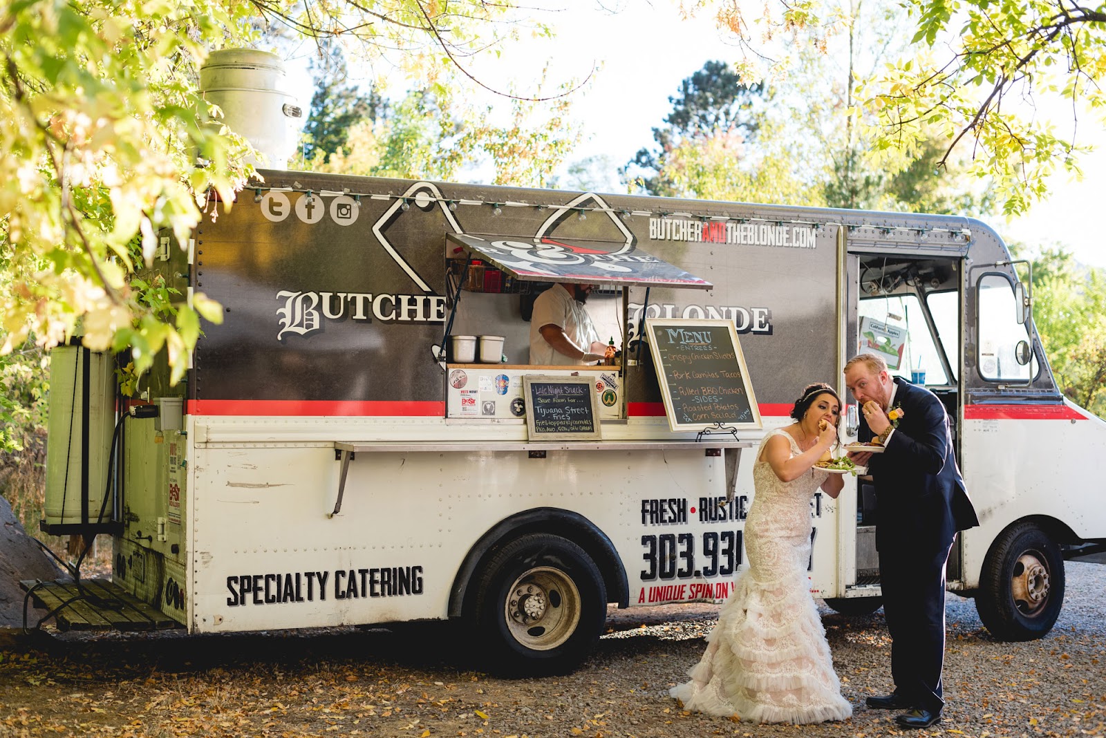 Bride and groom eating from a food truck at a wedding reception