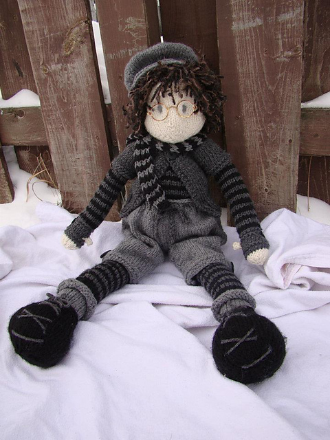 tall knit doll wearing black and gray with glasses
