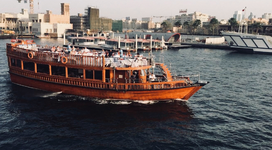 Barco na água com cidade ao fundo

Descrição gerada automaticamente