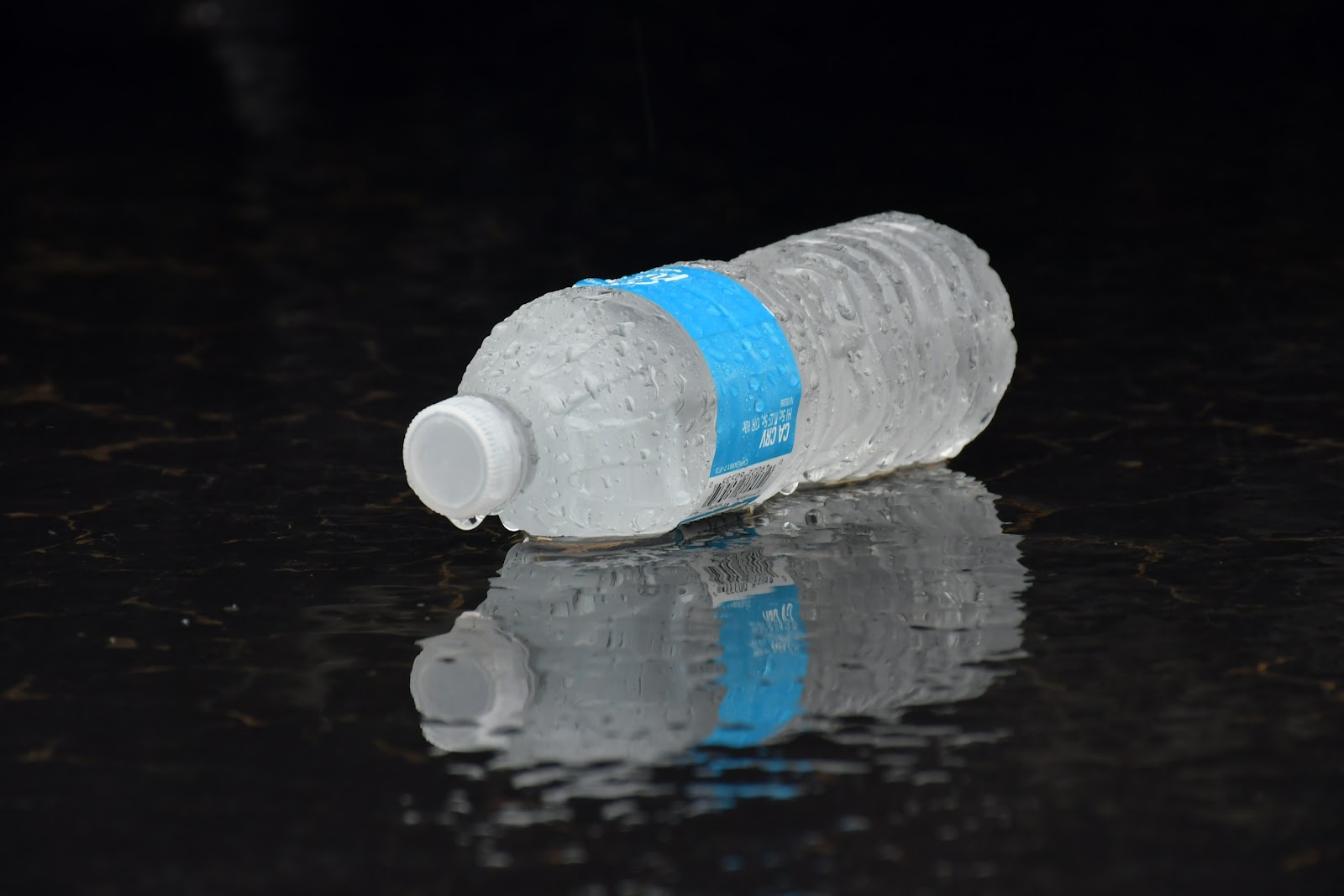 A bottle of water sits on the ground.