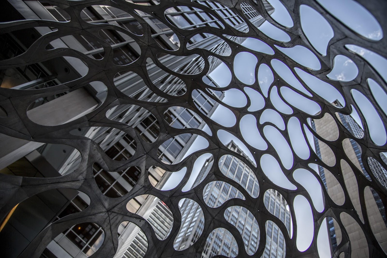 Skyscrapers viewed through a abstract metal sculpture.