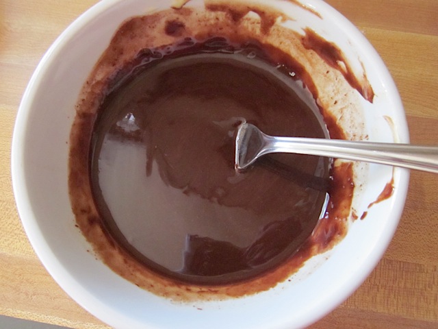 melted chocolate and butter in white bowl with spoon 