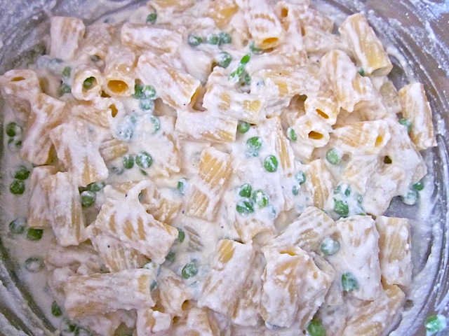 pasta and peas mixed with sauce mixture in bowl 