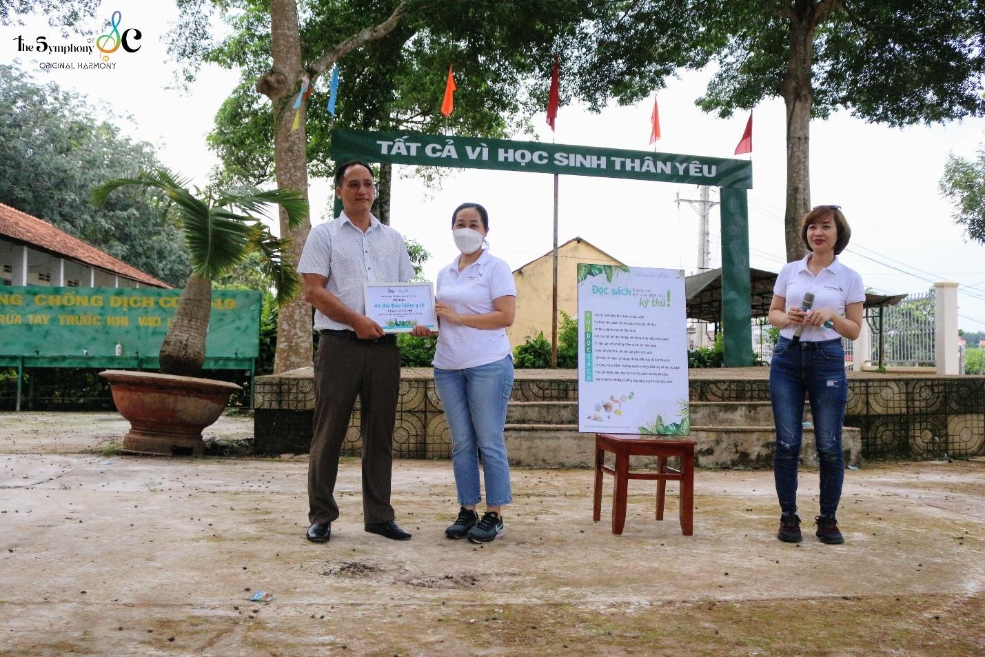 A group of people standing in front of a sign

Description automatically generated with medium confidence