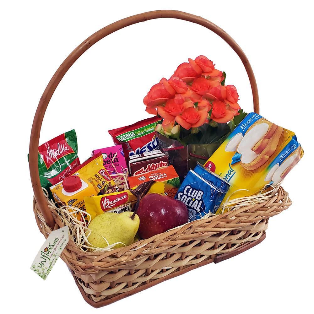 Cesta de café da manhã de luxo, com frutas, biscoitos, flores e achocolatados