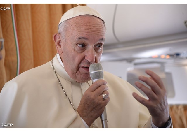 Pope Francis speaking to journalists on board the plane taking him to Poland. - AFP