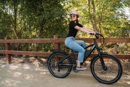 Woman riding her bike and smiling.