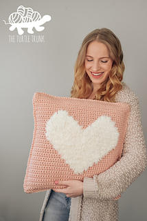 pink crochet pillow with faux fur white crochet heart in the center