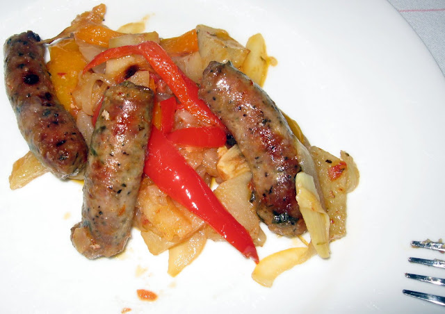 Finished product - Baked sausage and peppers dish featuring red and orange peppers.