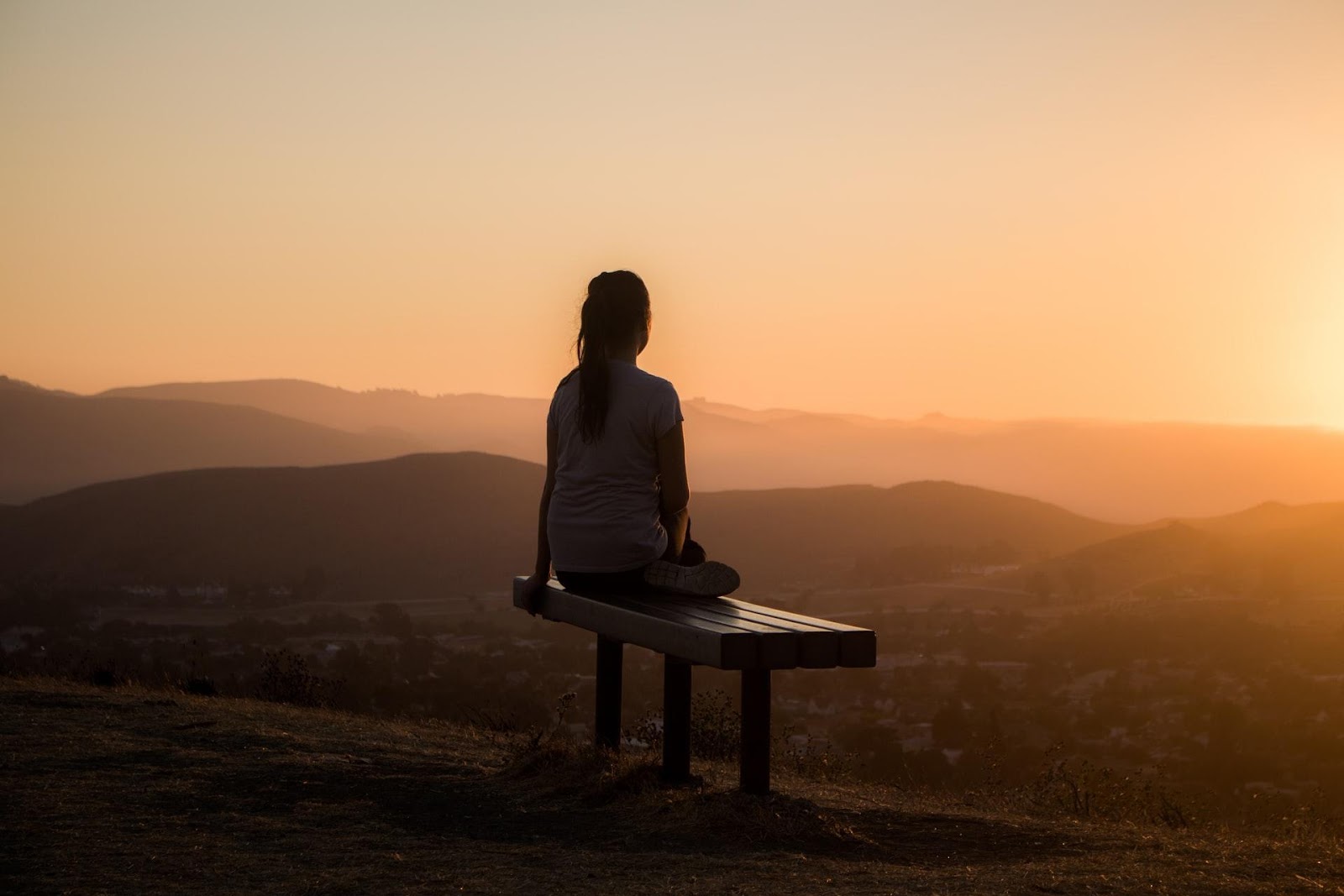 A picture of a woman watching the sunset because CarGuard Administration offers peace of mind for drivers.