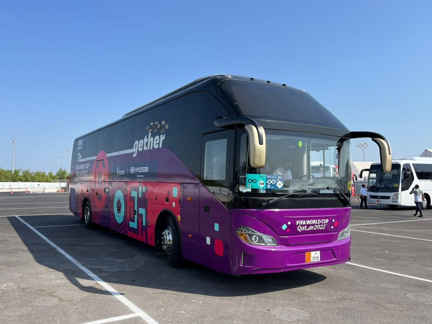 A purple bus parked in a parking lot

Description automatically generated