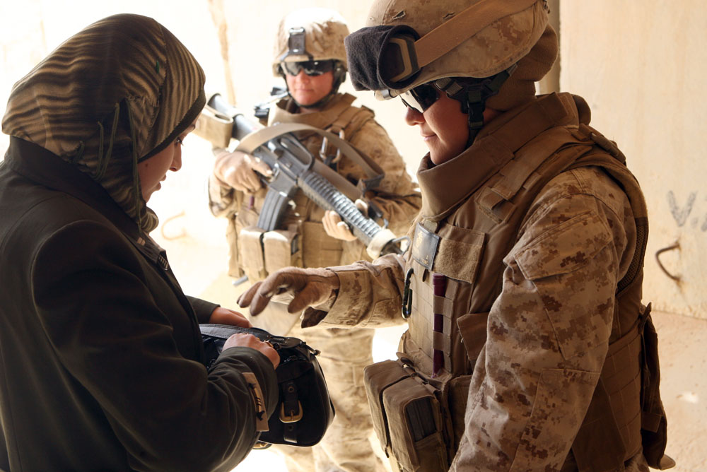 Female soldiers talking to a Muslim woman. Image via Wikimedia Commons.