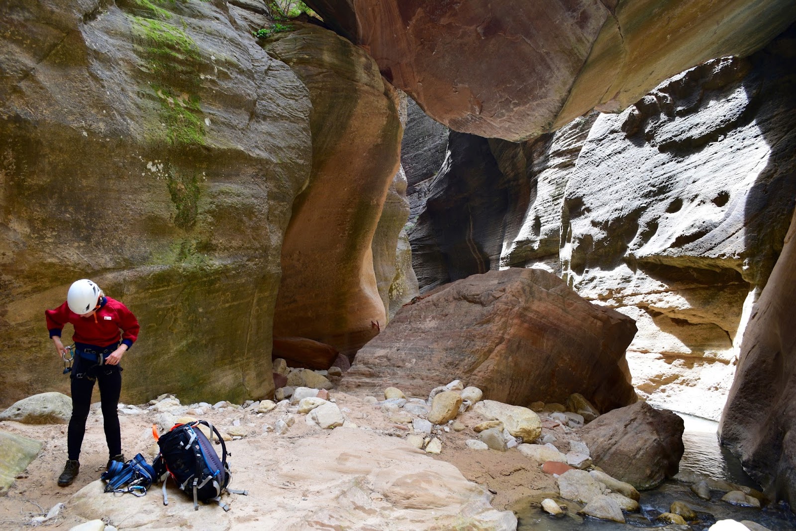 The edge of "the Guillotine" - an enormous boulder pinned in the narrows of Orderville Canyon.  The rigging for a short rappel can be seen on the left wall.  No telling how deep, so it's time to gear up!