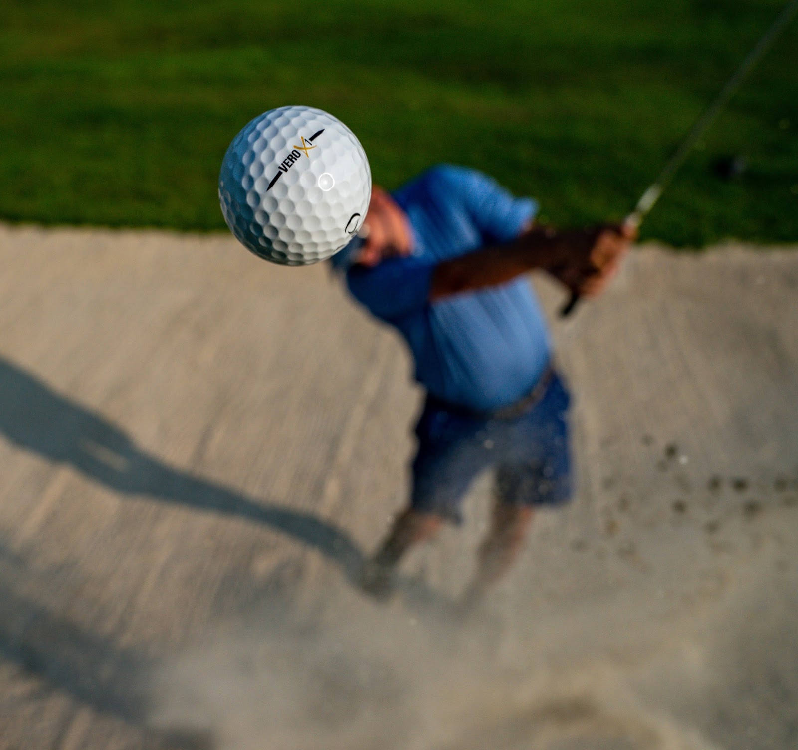 golfer hitting ball out of sand bank
