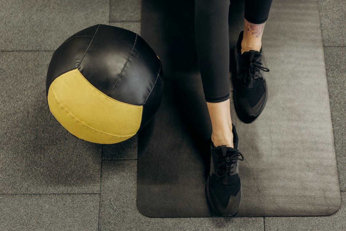 Free Person Standing On A Mat Beside A Ball Stock Photo