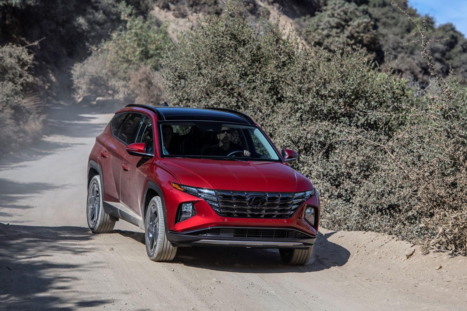 A red car on a dirt road Description automatically generated with medium confidence