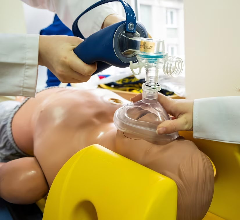 Medical students practising emergency cardiopulmonary resuscitation on a medical practice doll.