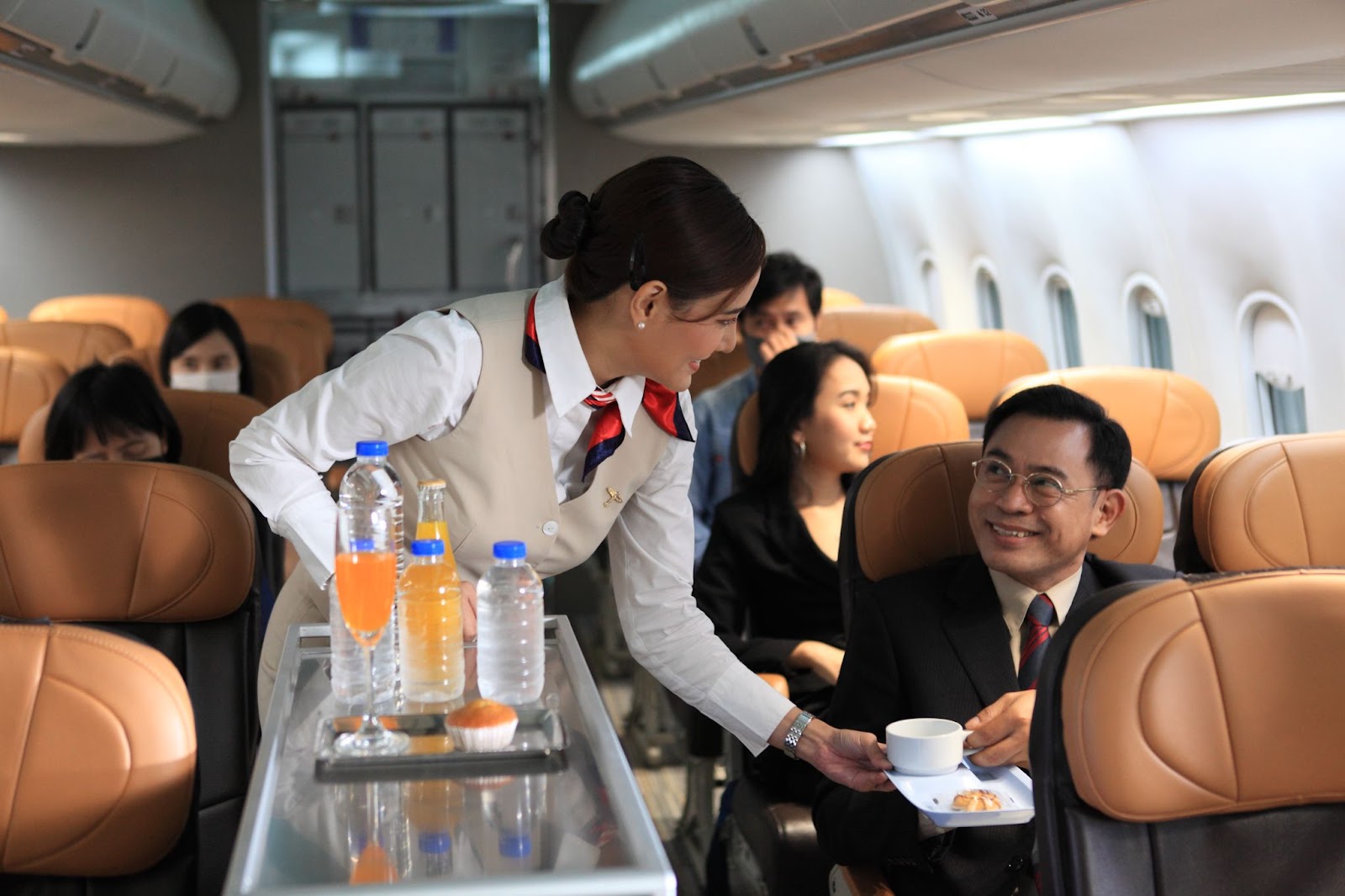 Cabin crew pushing service cart and serve to customer on the airplane during flight.