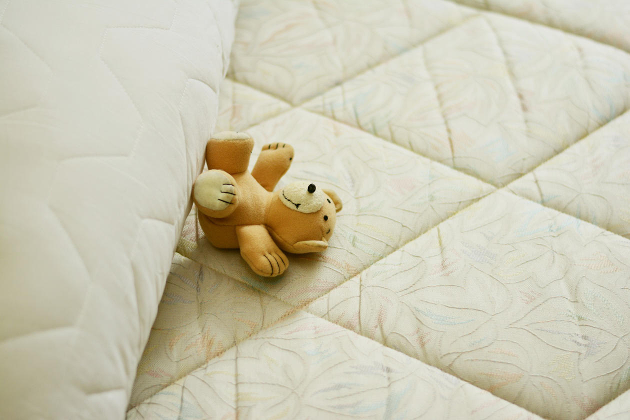 Cute little teddy bear on a mattress