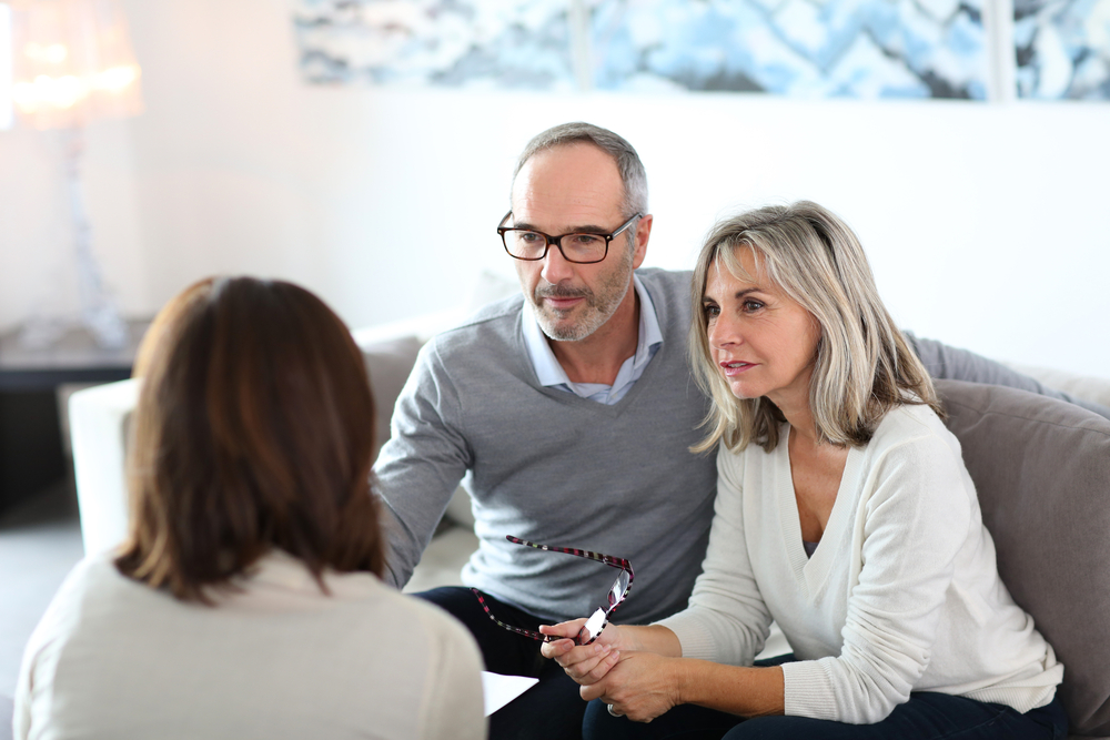 Mature couple sit in planning session with advisor.