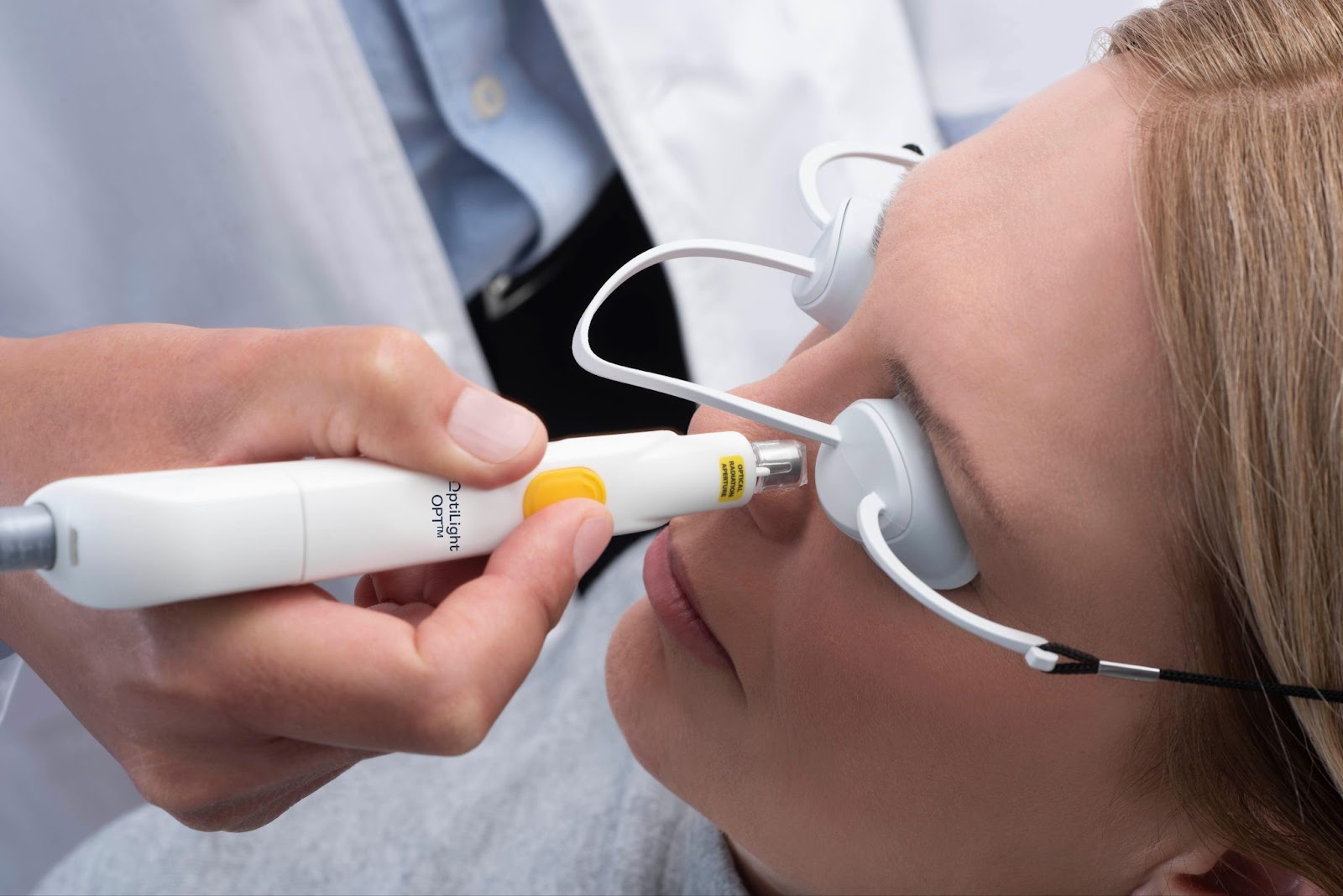 An optometrist uses an IPL device to provide treatment for a patient with dry eyes.
