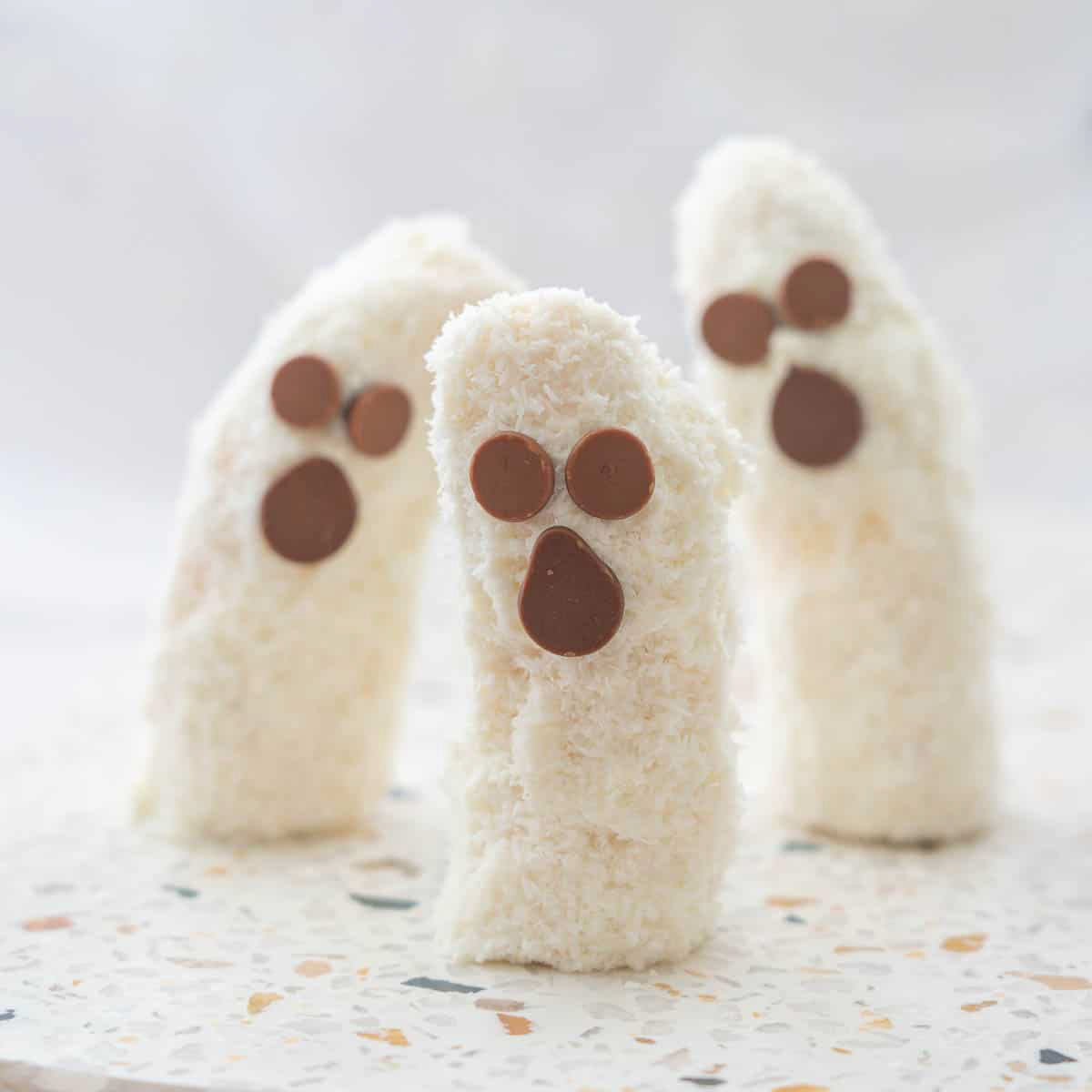 Coconut banana ghosts - healthy Halloween desserts - on a white background.