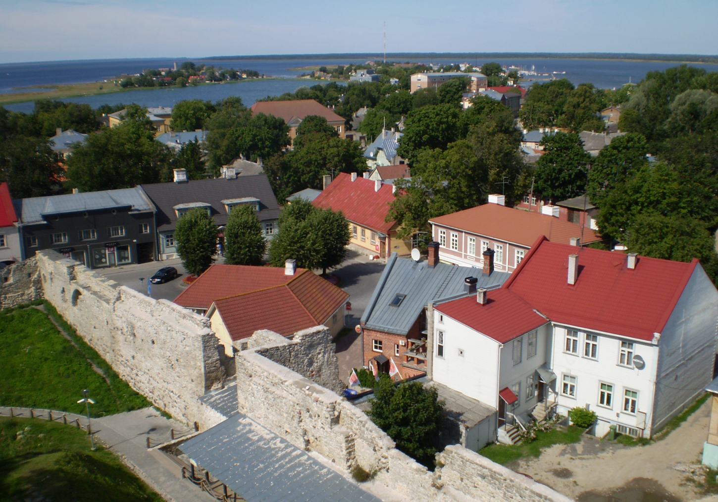 haapsalu cute white buildings with red roofs, seen from haapsalu castle. City view, surrounded by trees and baltic sea in the background.