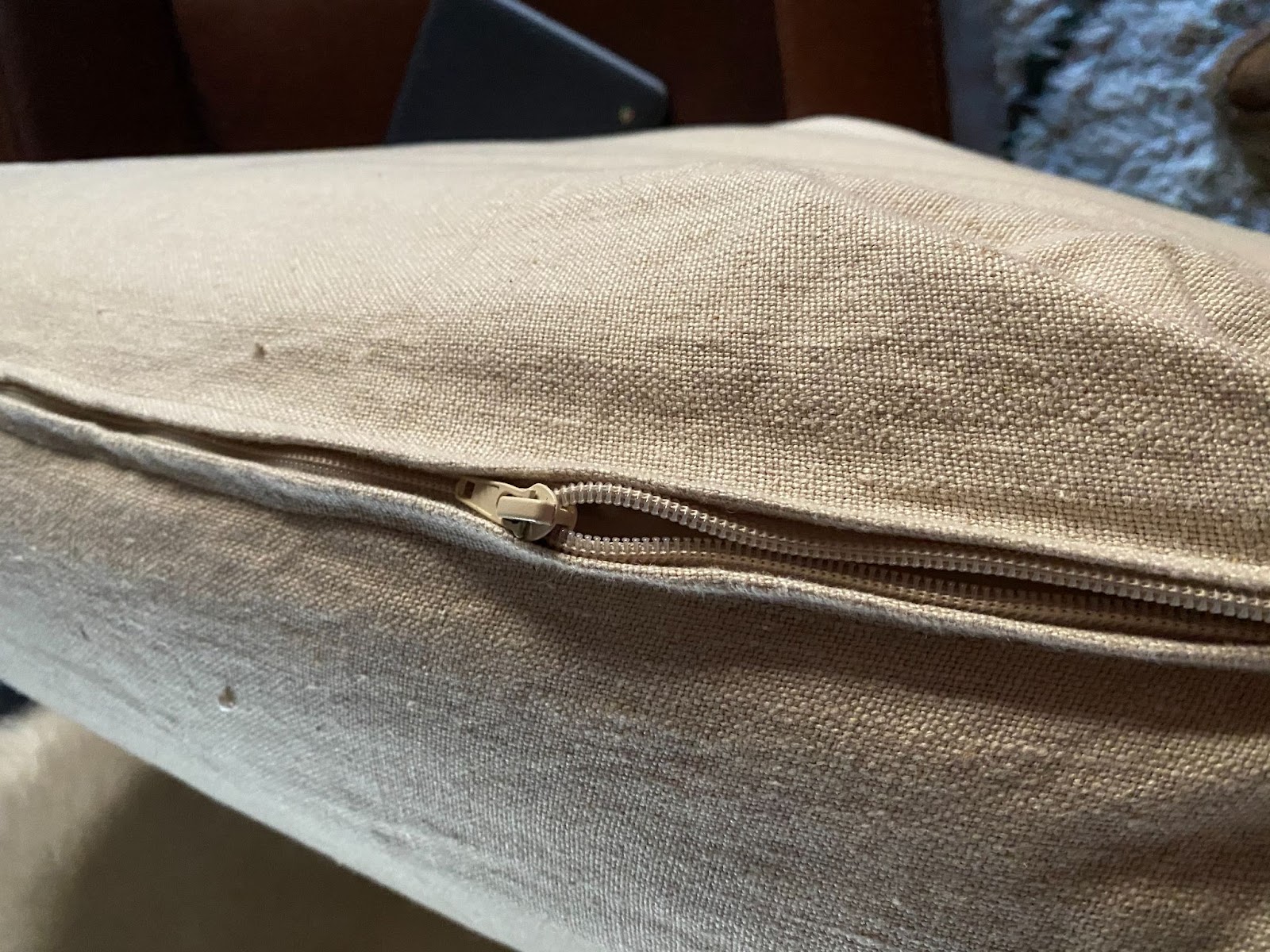 A zipper being zipped up on a sofa cover.