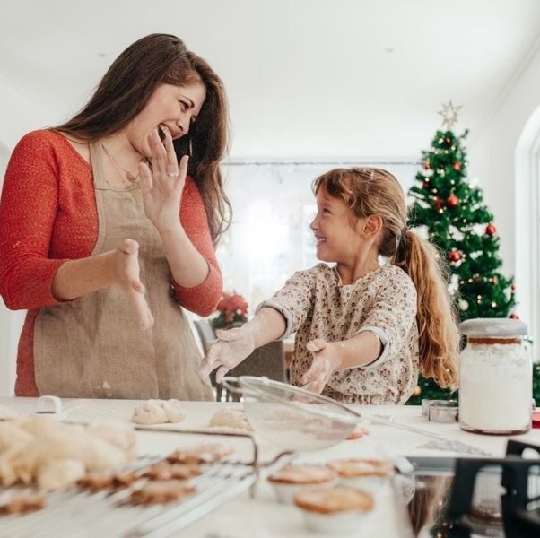 mother and daughter baking christmas cookies in the kitchen