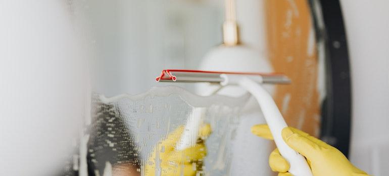 a person cleaning a mirror in the bathroom