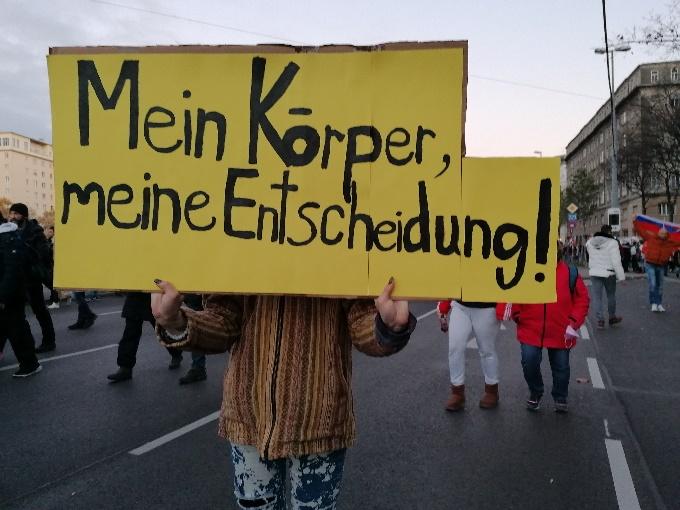 A person holding a yellow sign

Description automatically generated with medium confidence