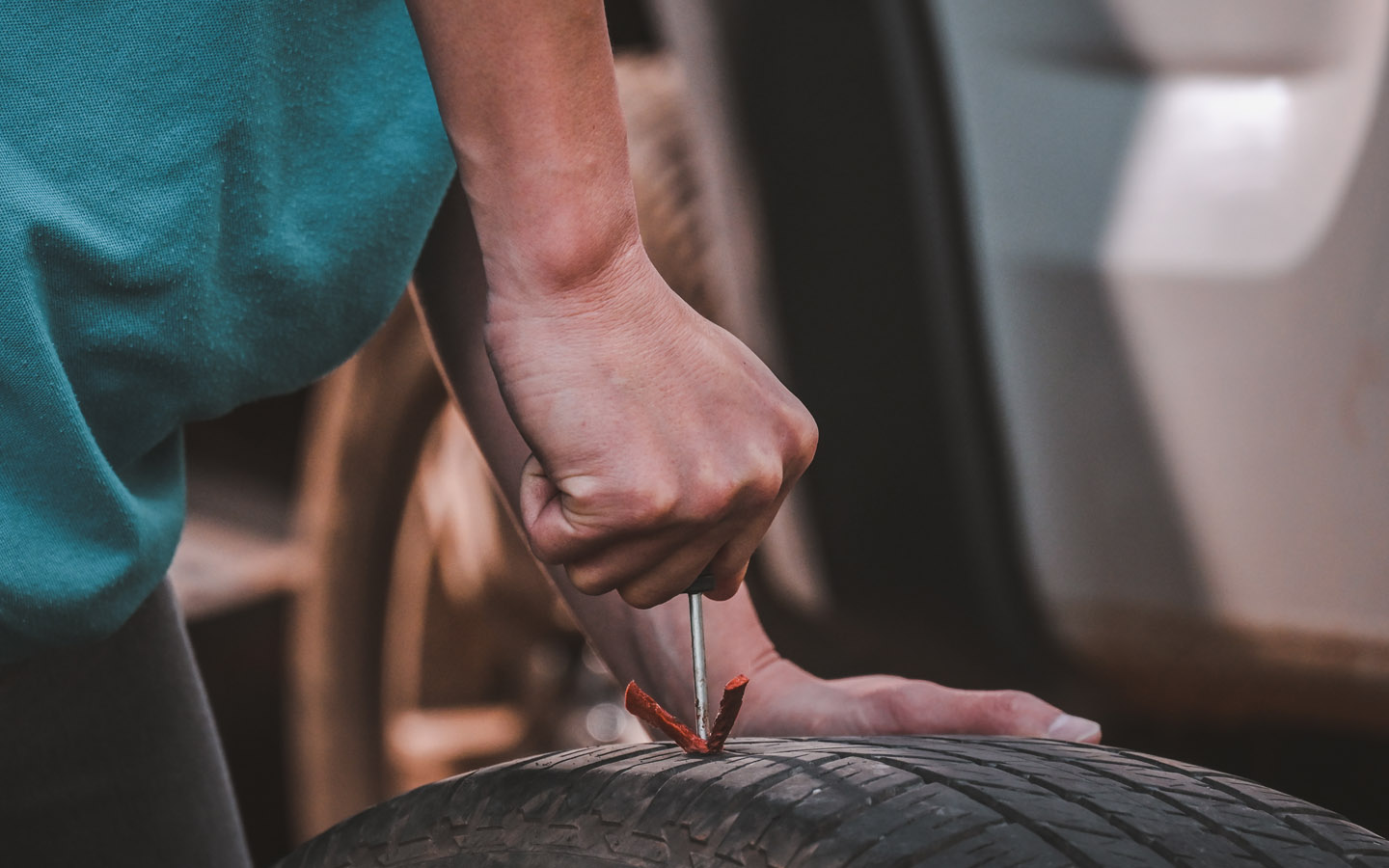 how to plug a leaky tyre. man inserting pkug strip in tyre