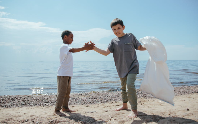 Two kids are cleaning the beach
