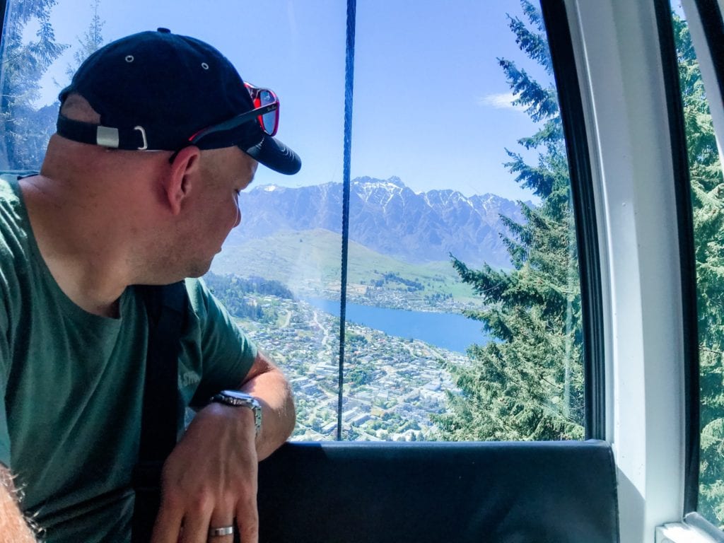 man in the skyline gondola looking at the view of Queenstown, New Zealand