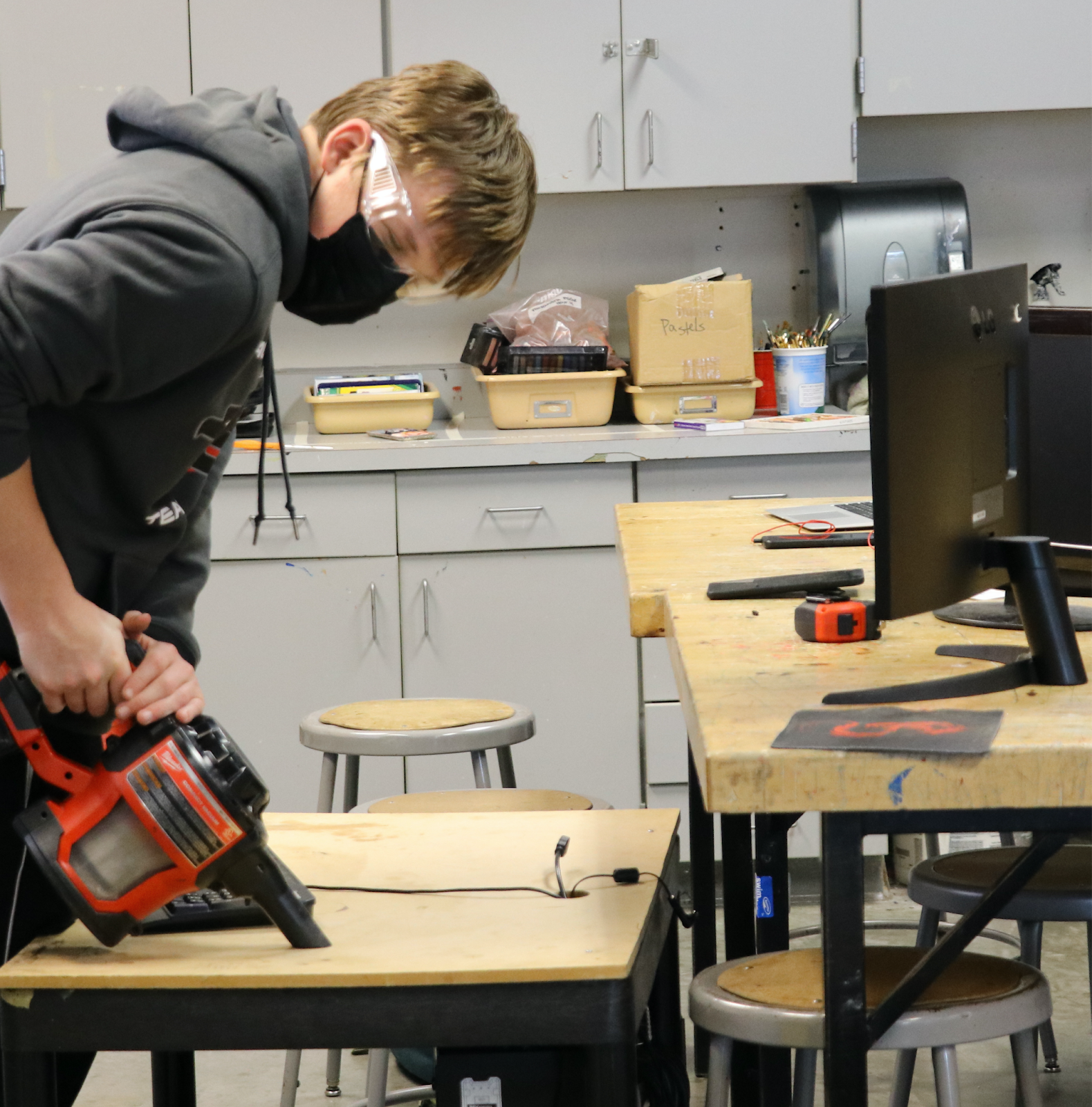 a student using a vaccum on a desk