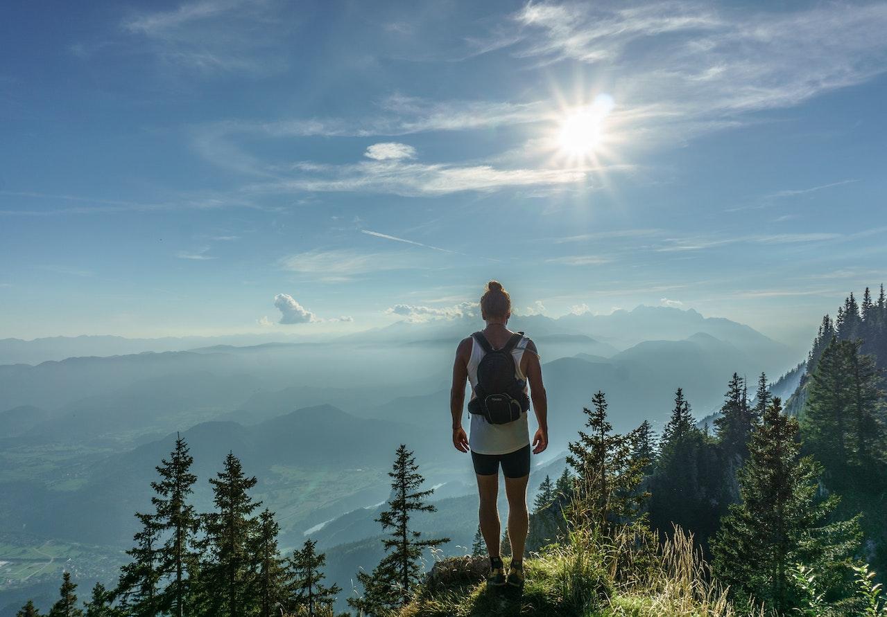 A person standing on a cliff overlooking a valley - Hiking Problems