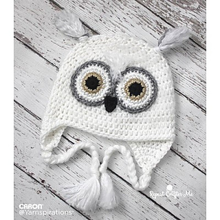 snowy owl hat lying flat on white wooden background