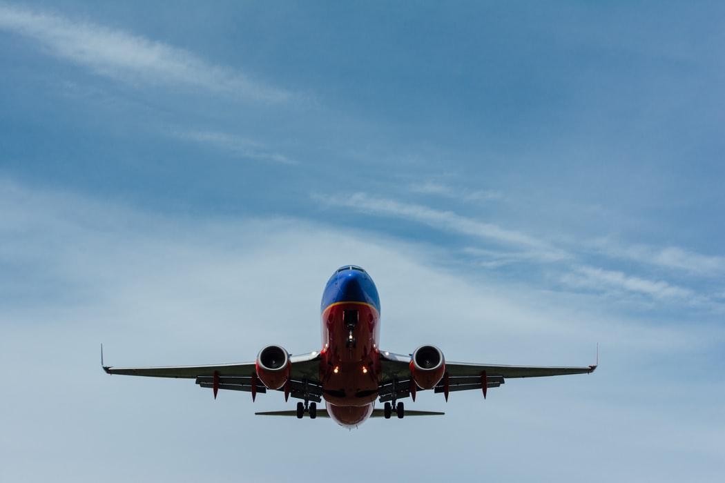 A large passenger jet flying through a cloudy blue sky

Description automatically generated