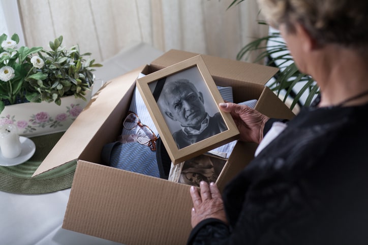 woman looking at photos while packing them into a box.