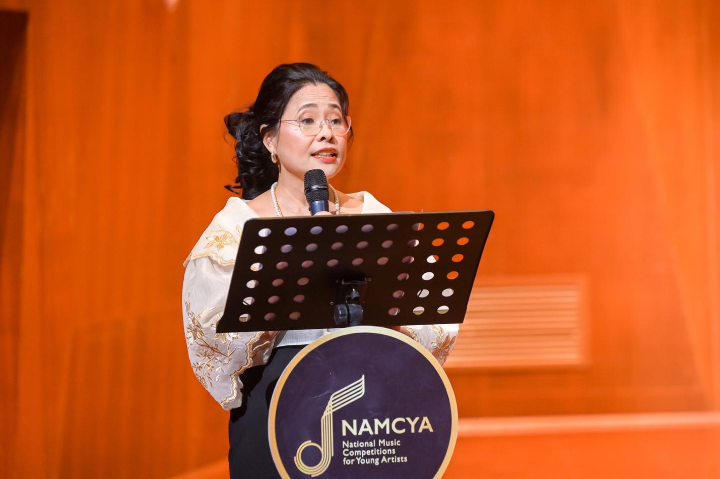 A person standing at a podium with a microphoneDescription automatically generated