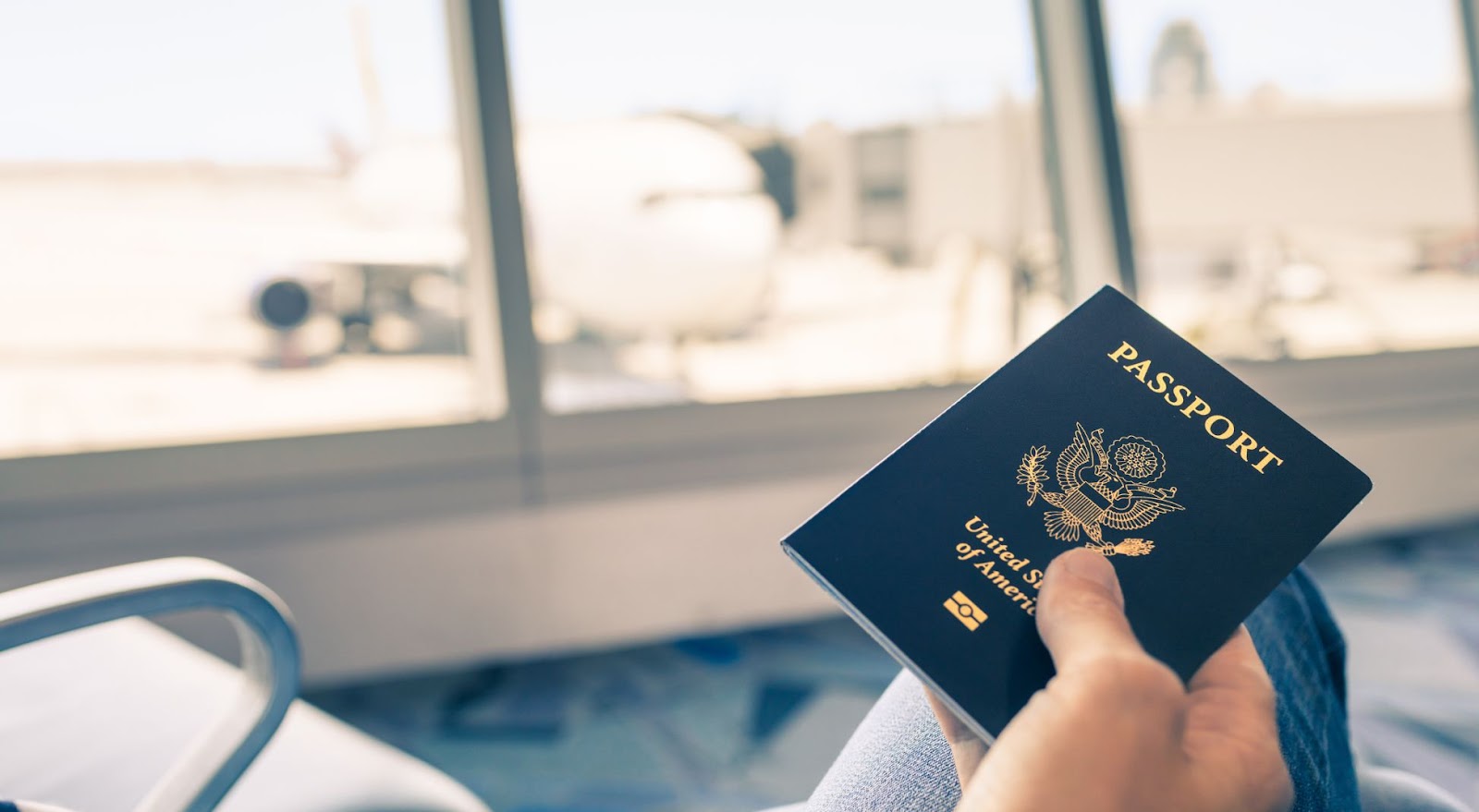 Traveler at airport holding passport in hand