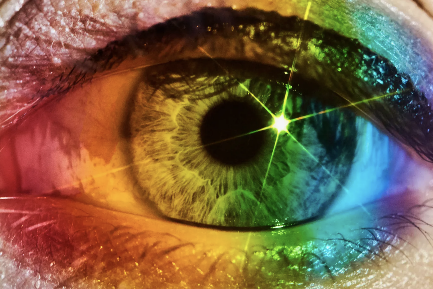 Foto colorida de um olho claro com filtro multicolor e foco de luz artificial