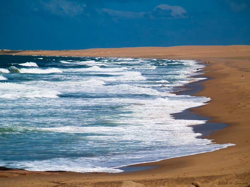 Vista de la playa de Cabo Polonia, uno de los parques nacionales de Uruguay; una extensa franja de dunas de arena se extiende frente al mar.