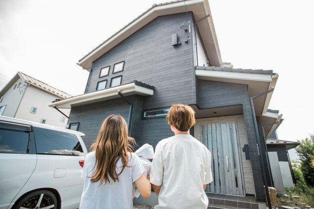 住宅を見上げる夫婦の写真